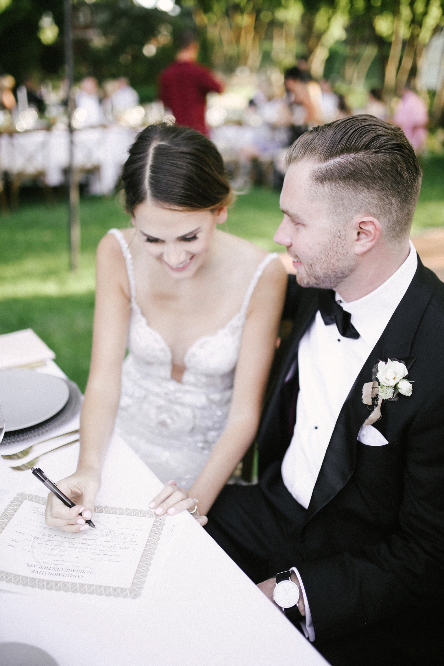 A bride and groom signing their wedding license.