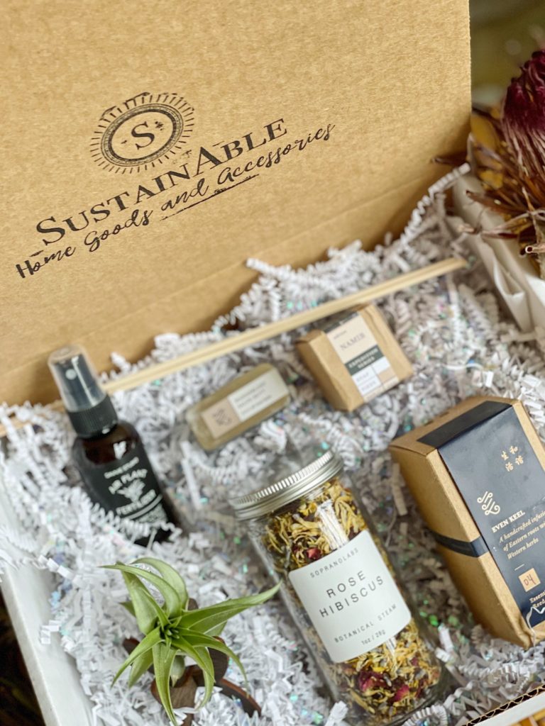 A gift box filled with a small bottle of rose hibiscus leaves, a spray, a soap and 3 other mini gifts. One of our recommendations for the wedding gift guide.